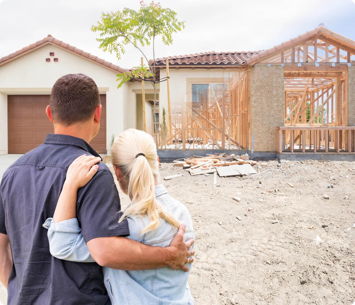 Home construction with couple looking on