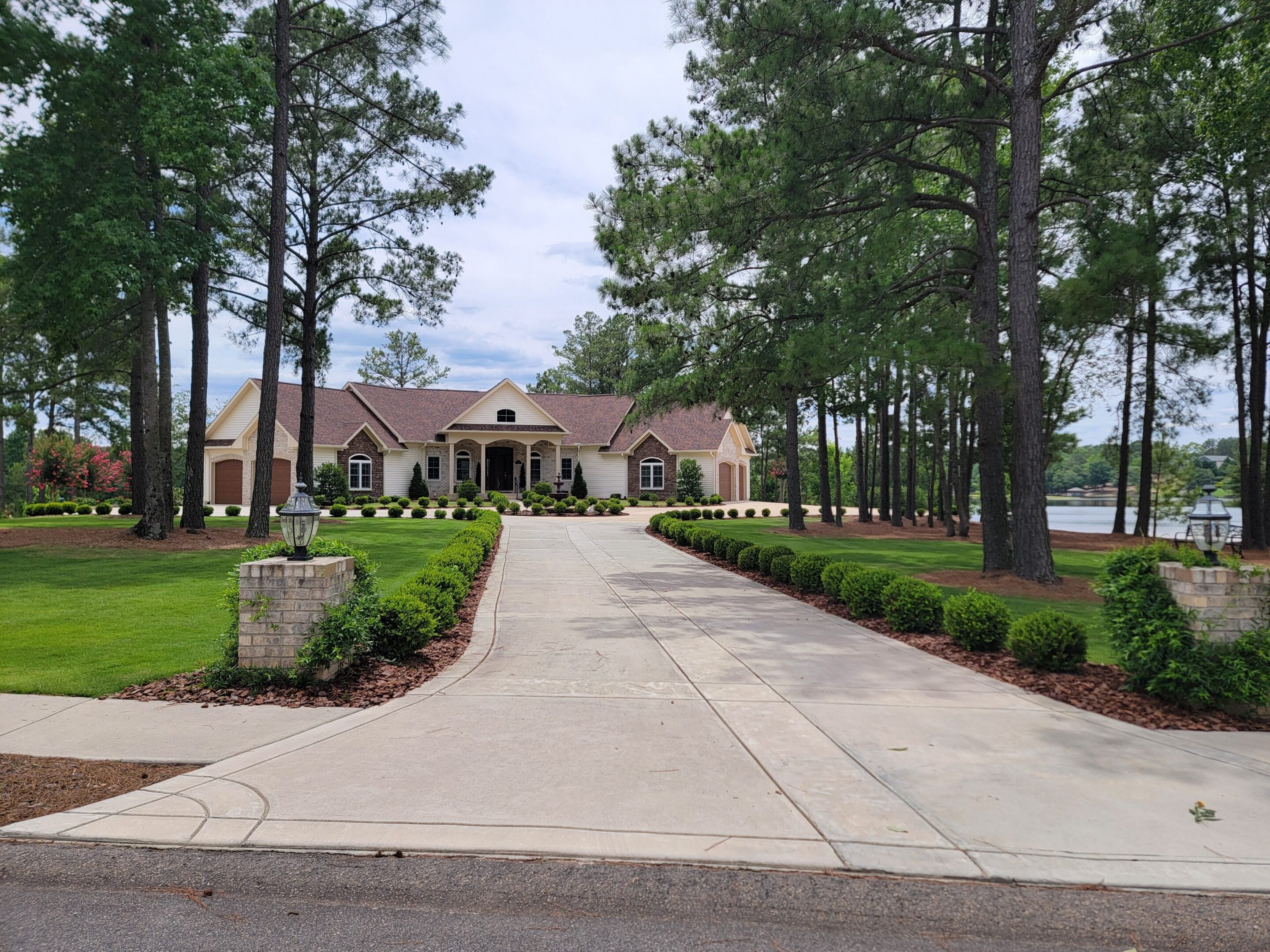 Large house with driveway and surrounding trees.