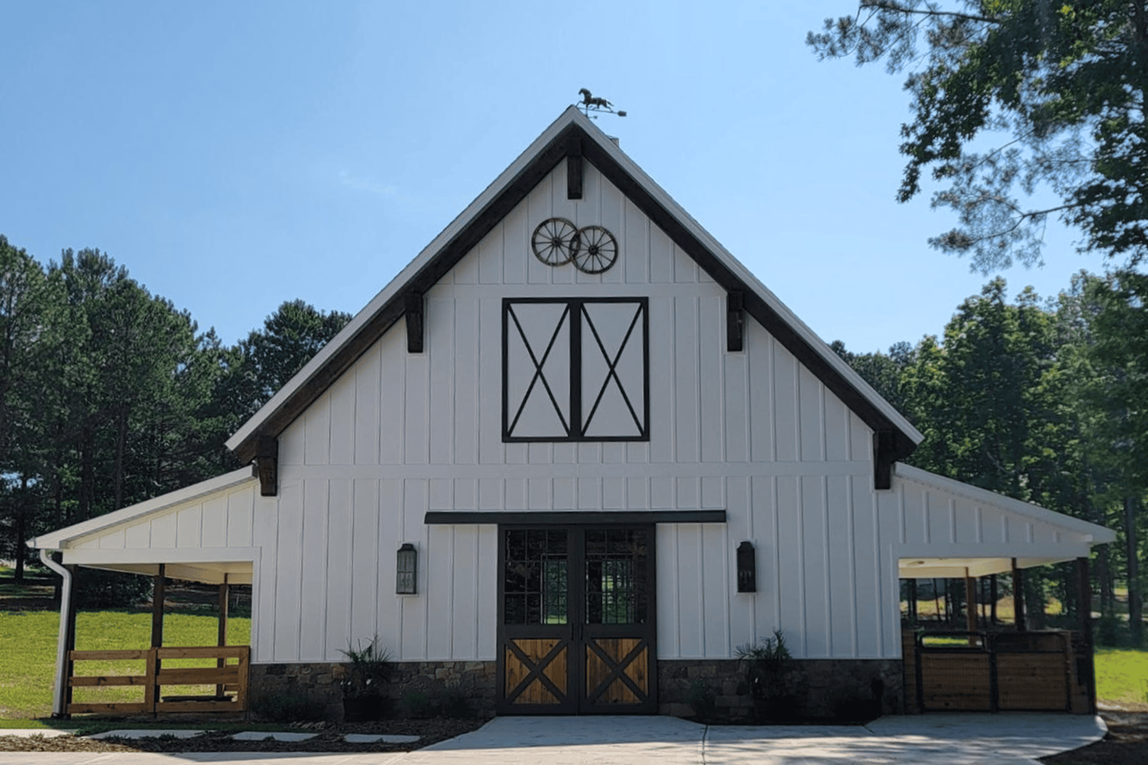 White barn with trees in the background.
