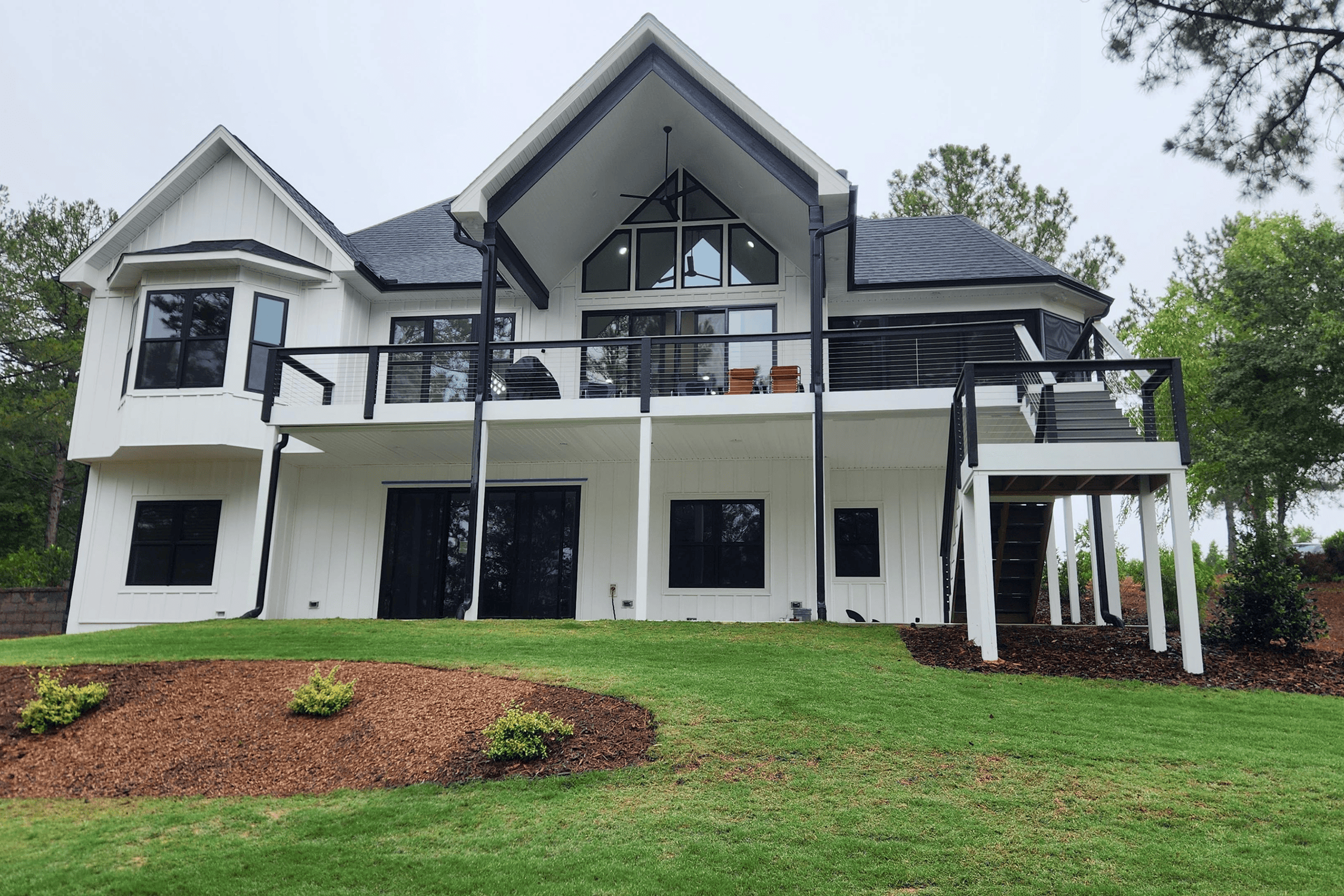 Modern white house with large windows and balcony.