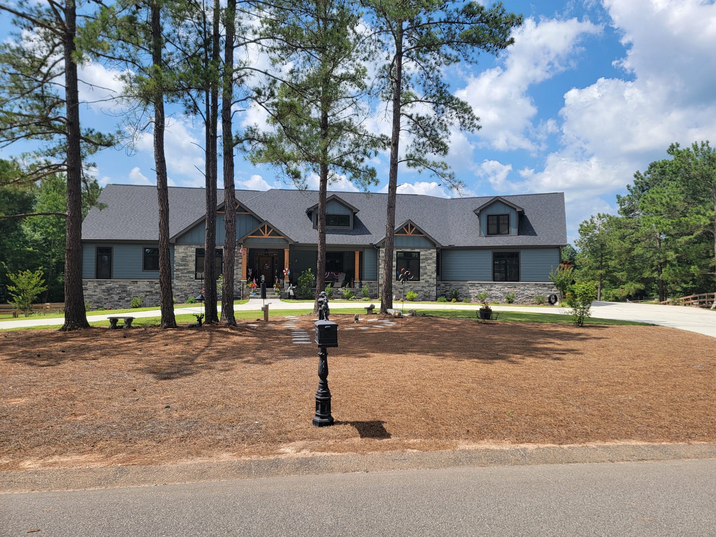 Large house surrounded by tall trees.