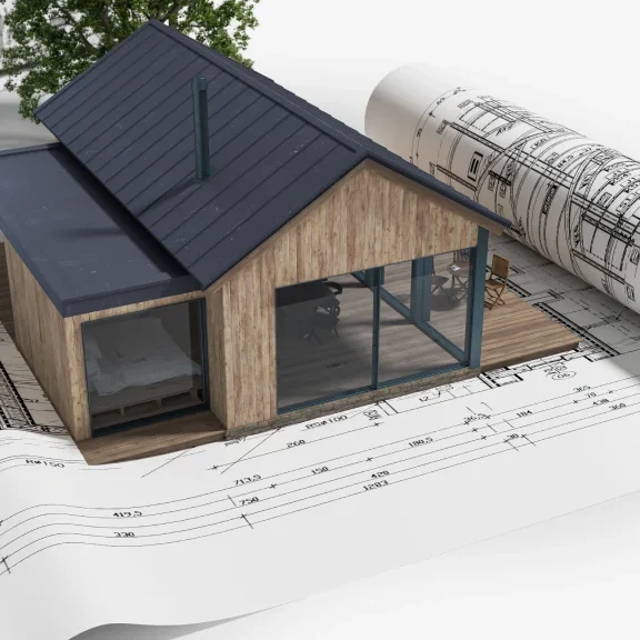 Miniature house surrounded by design plans